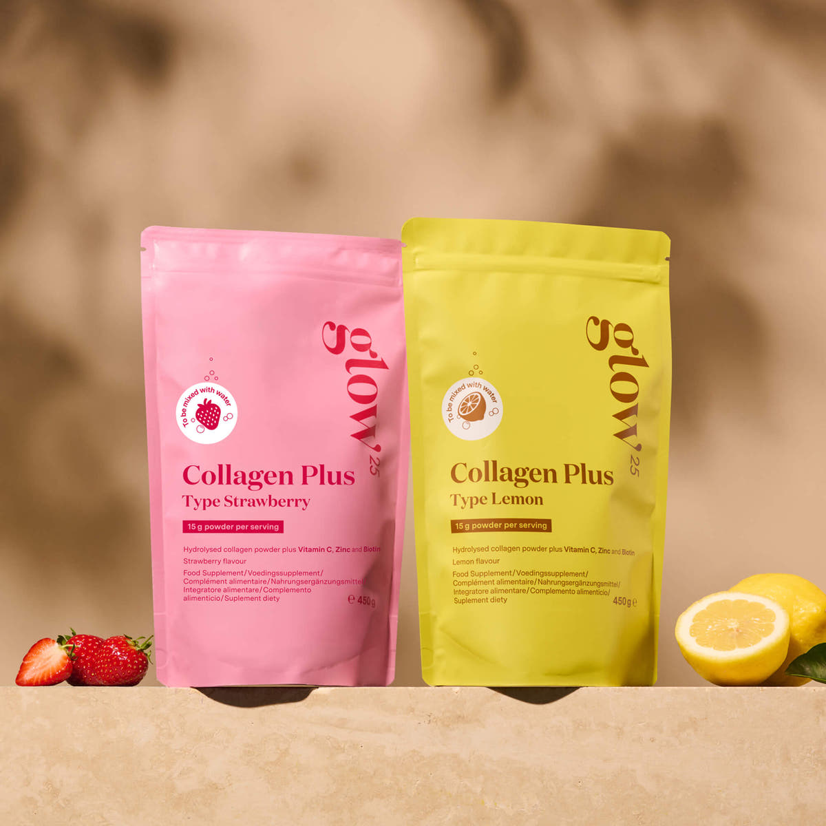 Glow25 Collagen Plus Type Strawberry and Type Lemon pouches beside strawberries and a lemon