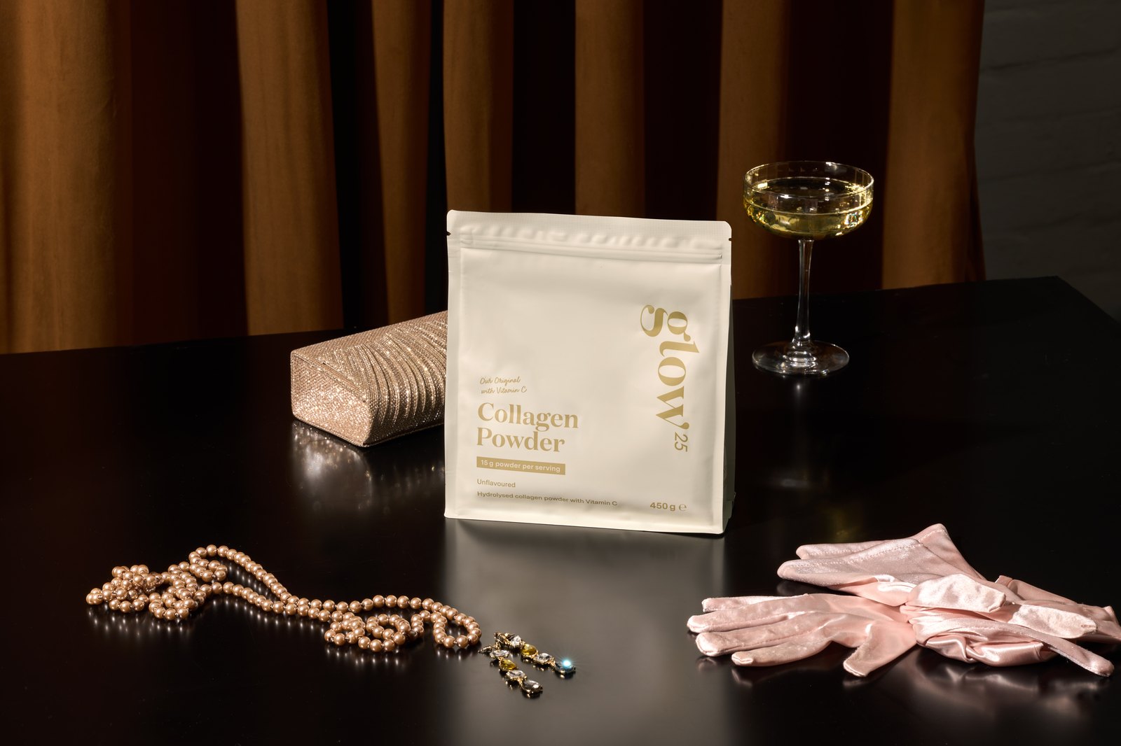 Glow® Cinema: Glow25 Collagen Powder with satin gloves, clutch bag, pearl necklace and champagne glass on the VIP evening