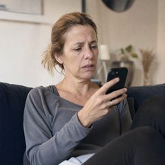Frau liest eine Nachricht auf dem Handy noch einmal